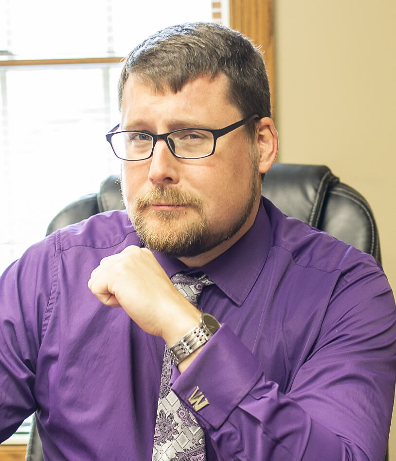Wesley C. Buchanan in purple shirt looking at camera